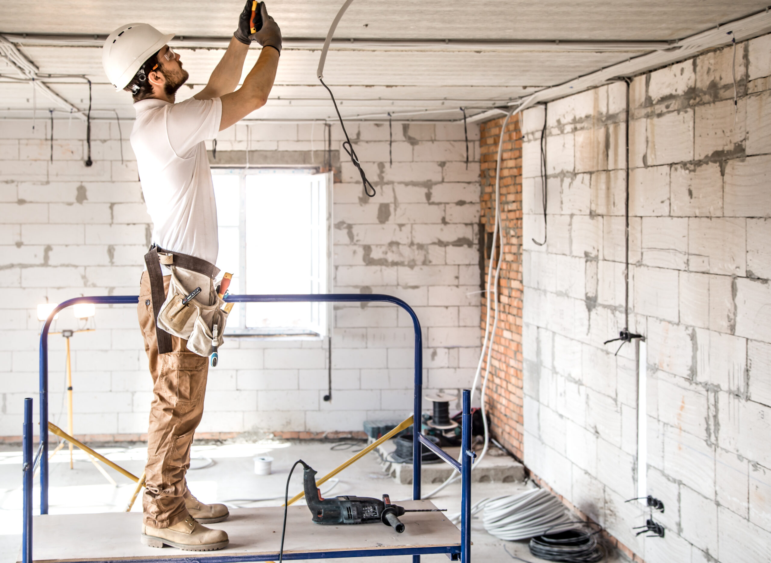 Électricien professionnel sur un chantier Électricien en action sur un échafaudage