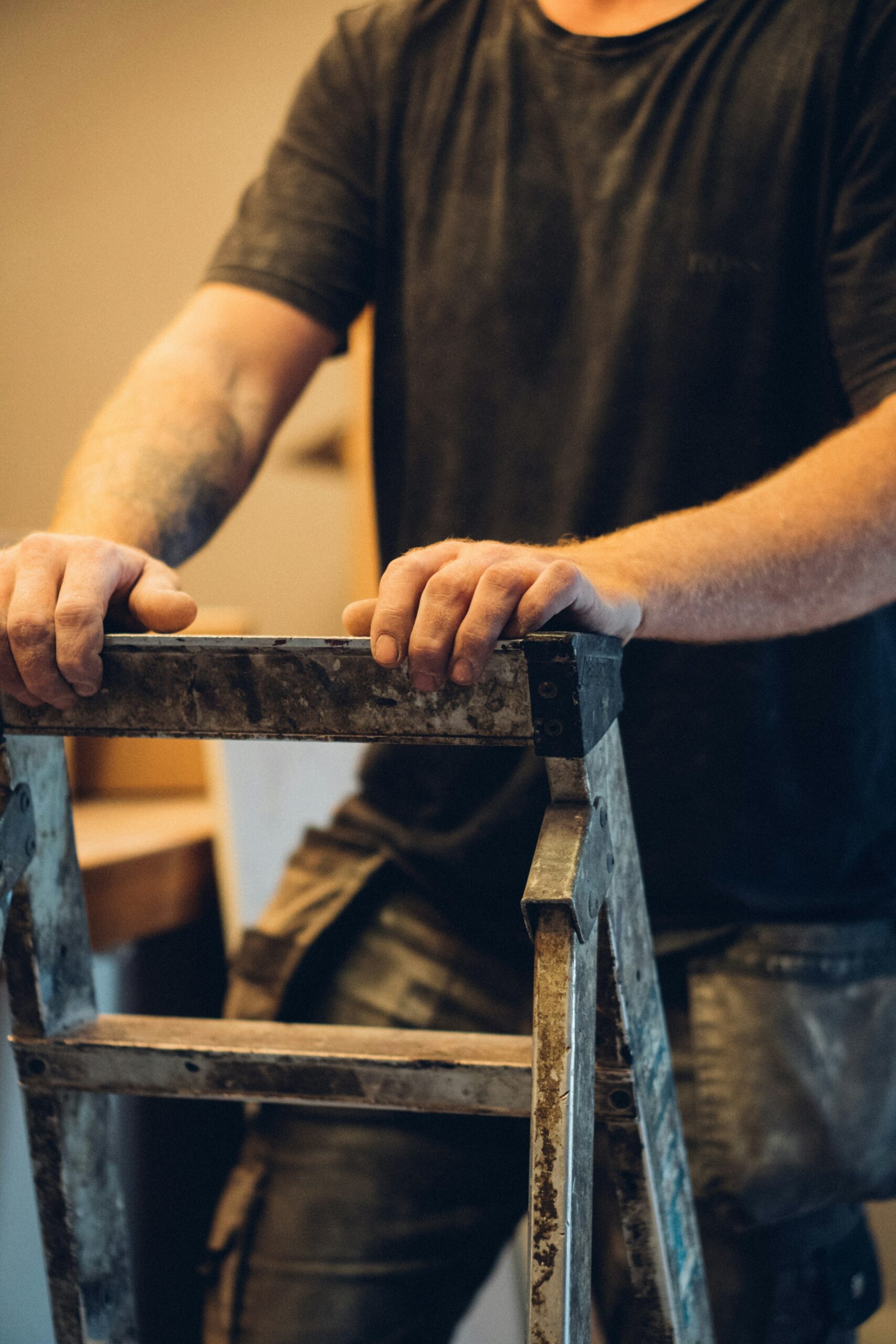 Montée sur l'escabeau Homme montant sur un escabeau sur un chantier
